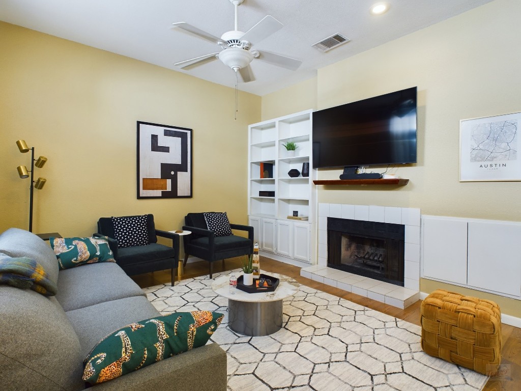 a living room with furniture a flat screen tv and a fireplace