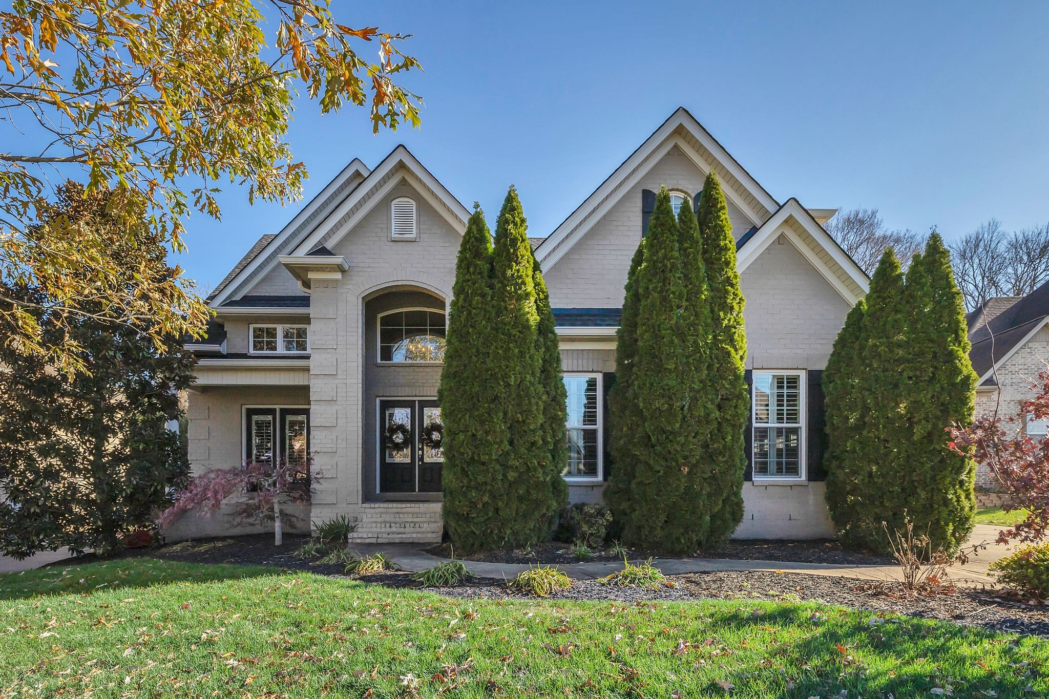 front view of house with a yard and plants