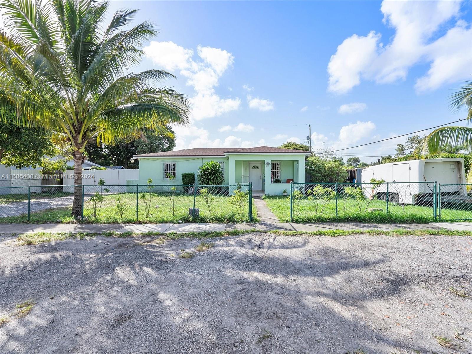 a view of a house with a backyard and a tree