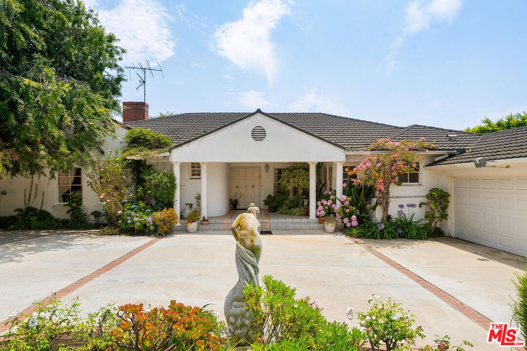 a front view of a house with a garden and pathway