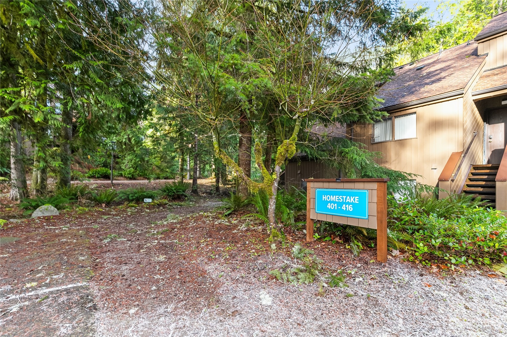 a sign board with a house in the background