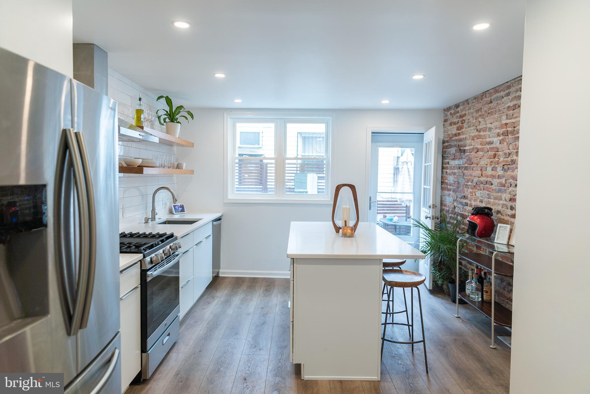 a kitchen with stainless steel appliances granite countertop a refrigerator sink and wooden floor