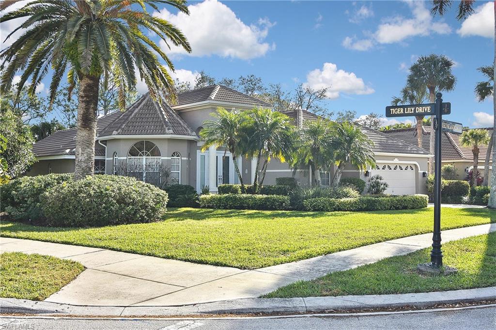 View of front of property with a front lawn and a garage