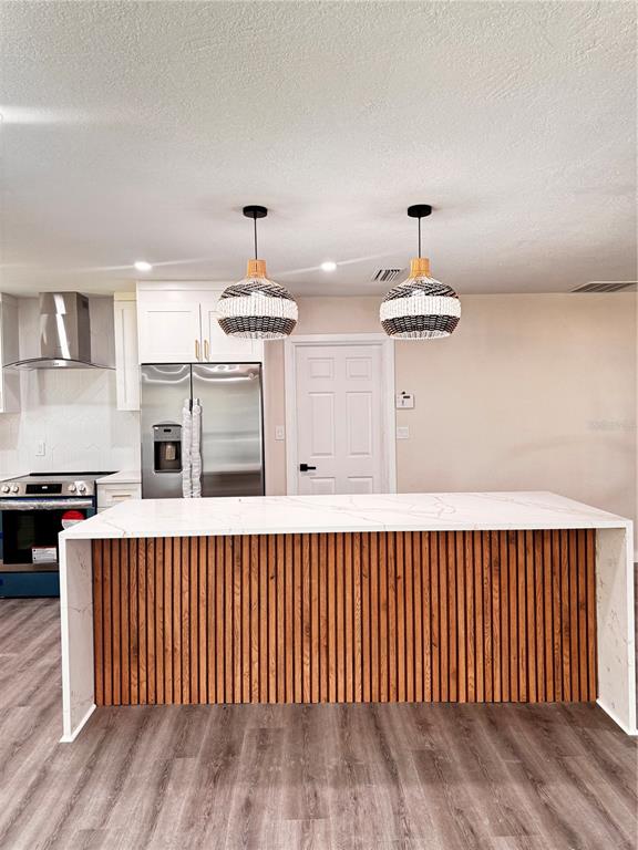 a kitchen with stainless steel appliances granite countertop a stove a sink and a refrigerator