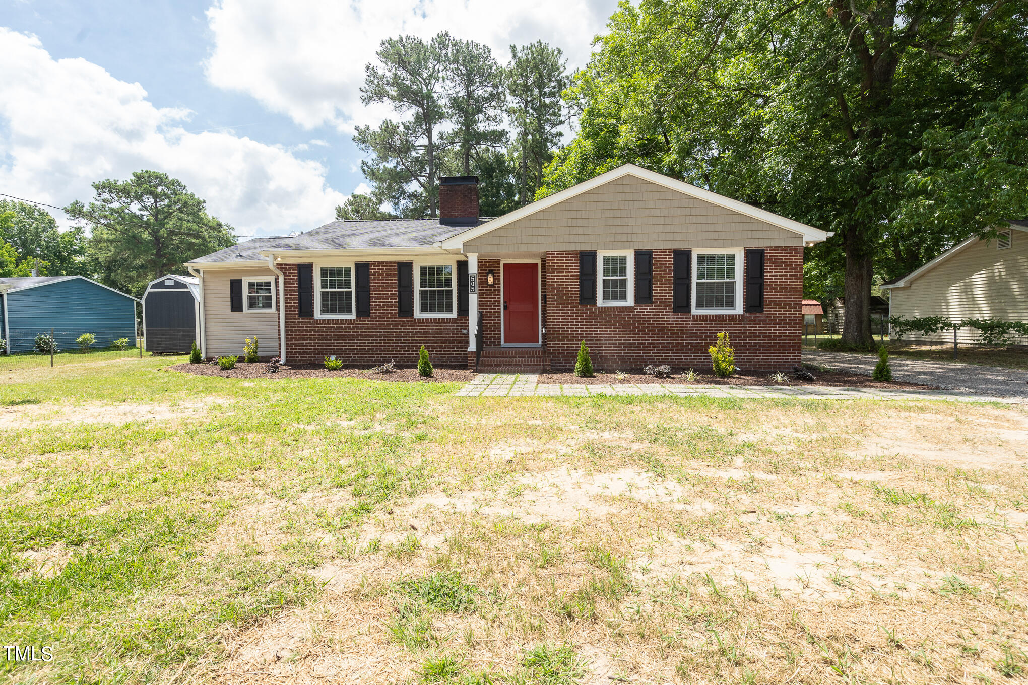 a front view of house with yard and trees around