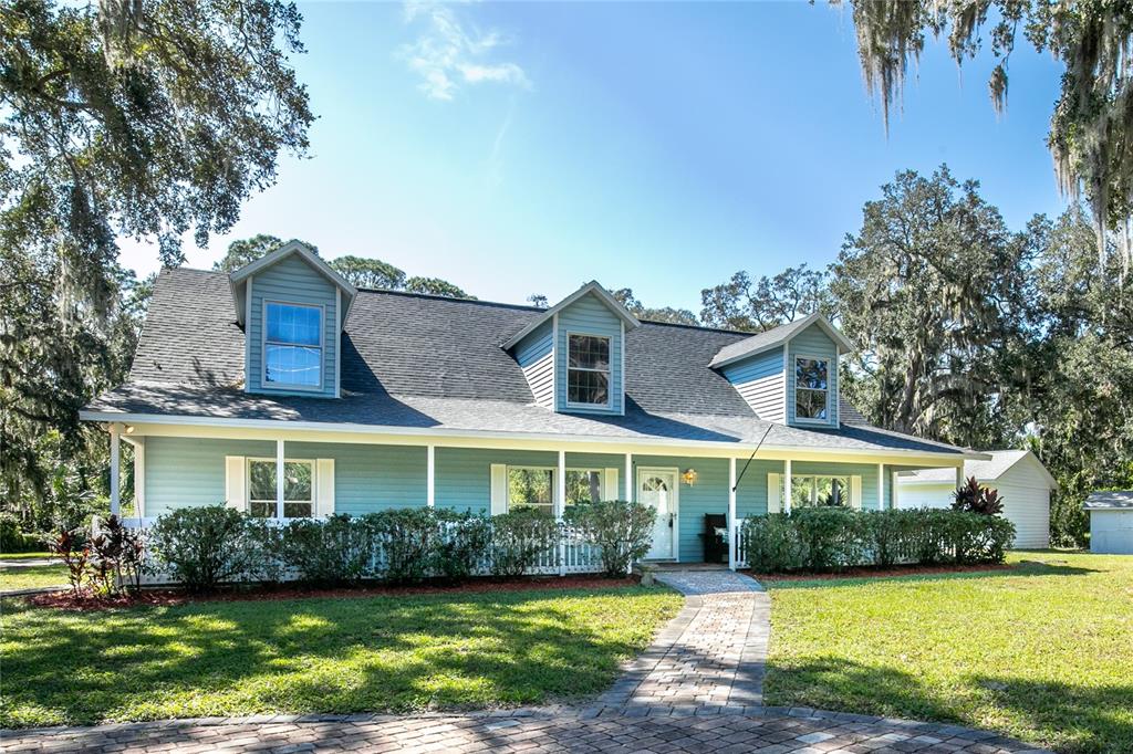 a front view of a house with a garden and swimming pool