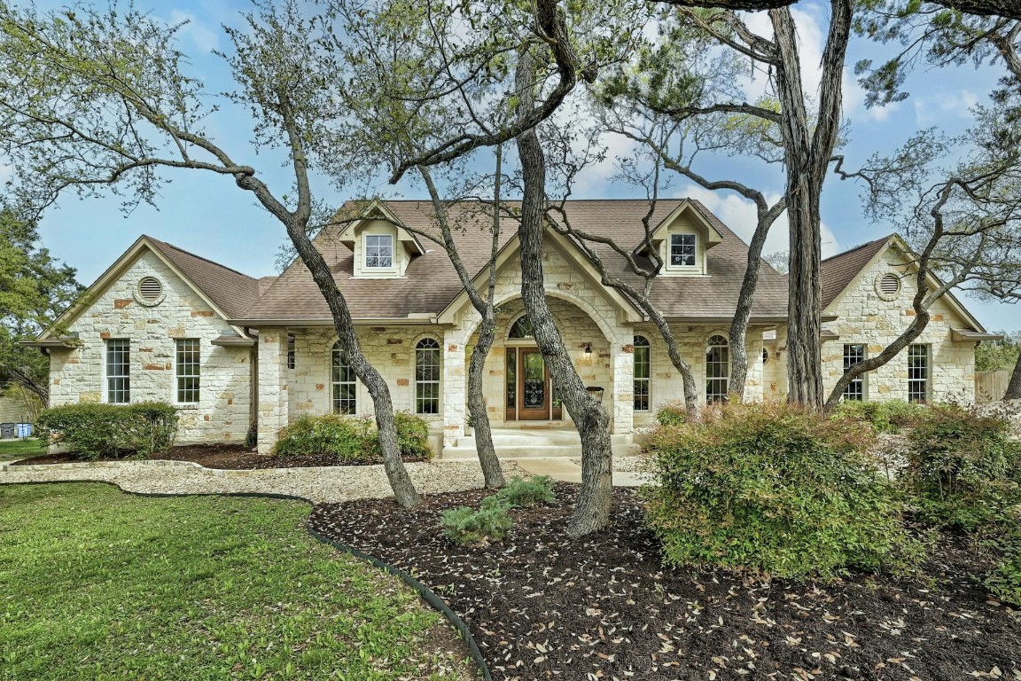 a view of a white house with a big yard and large trees