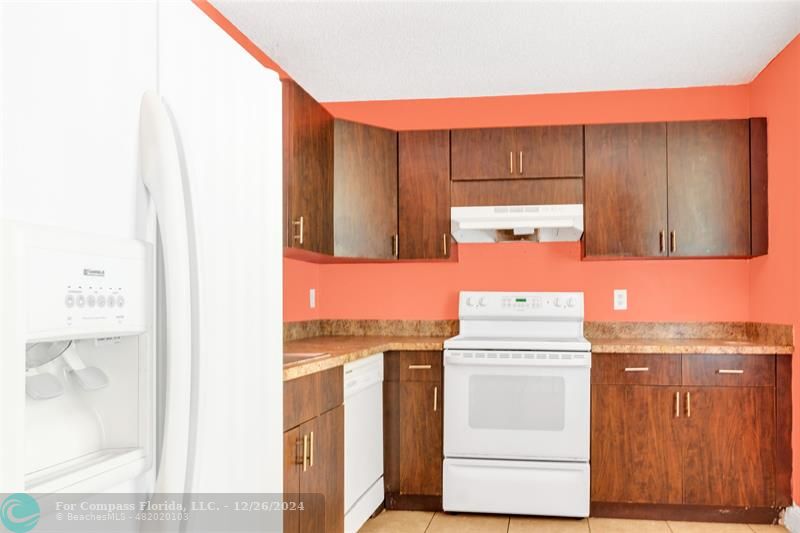 a kitchen with a sink a stove and cabinets