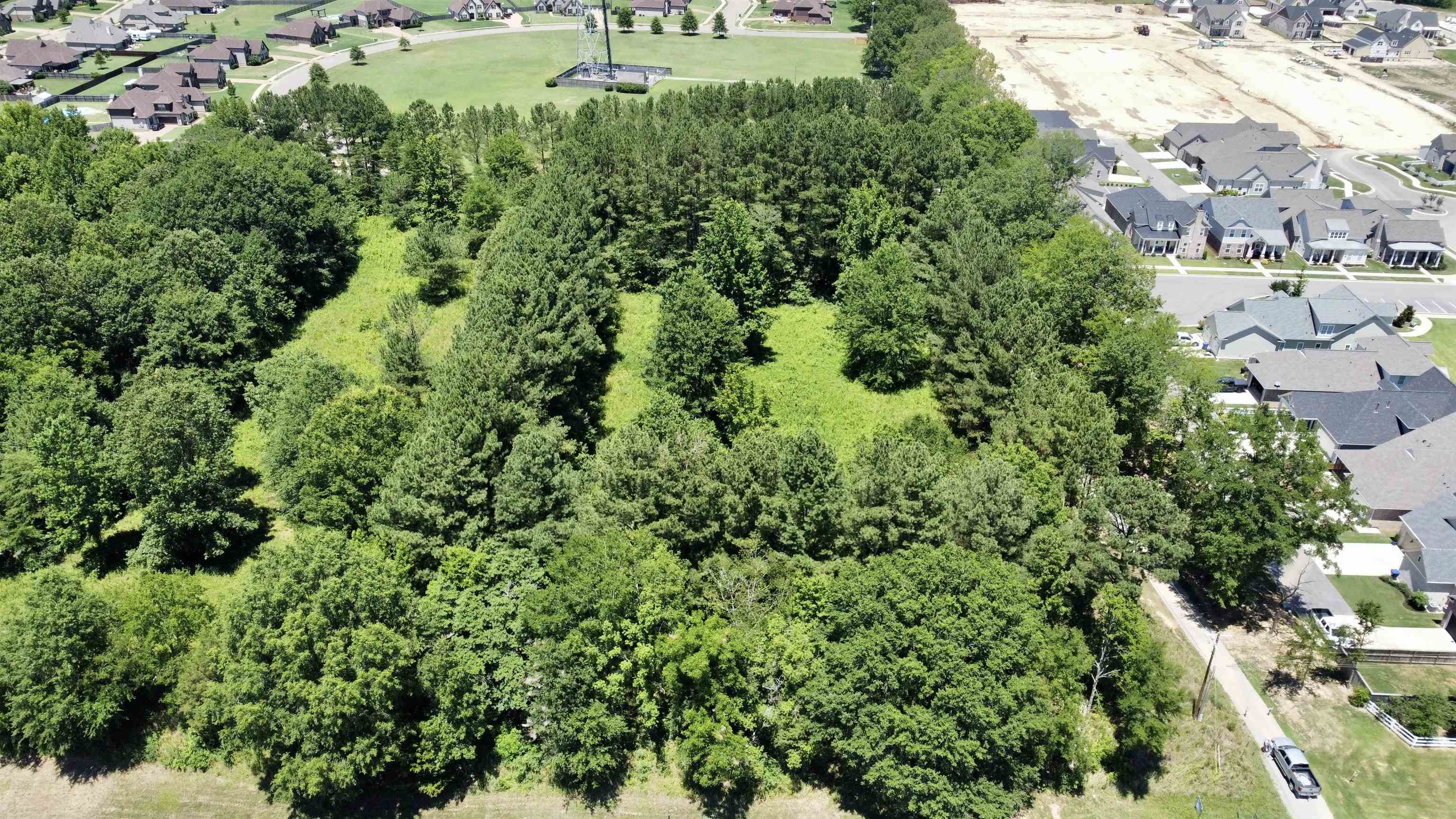 an aerial view of residential house with outdoor space and trees all around