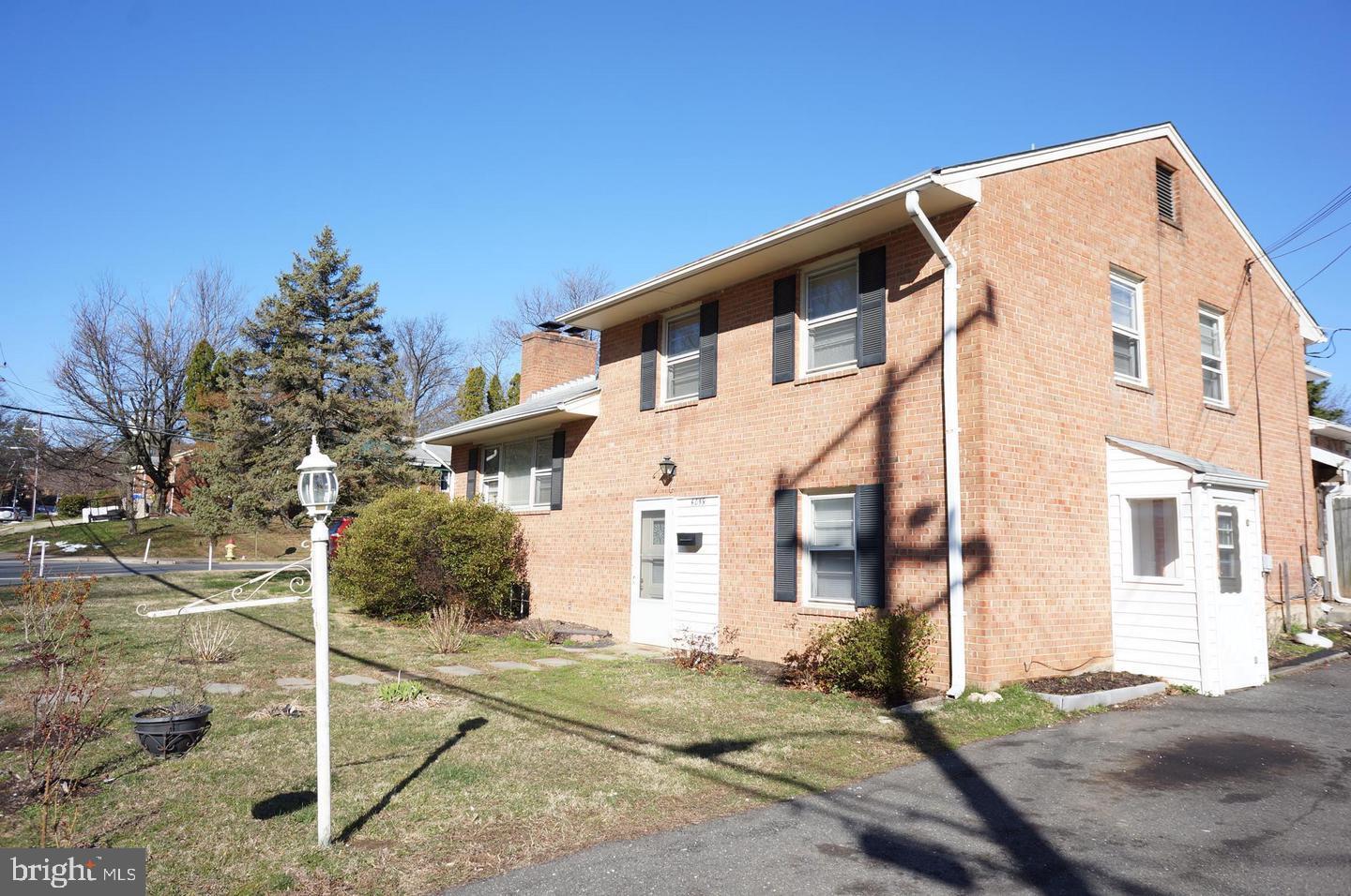 a front view of a house with a tree