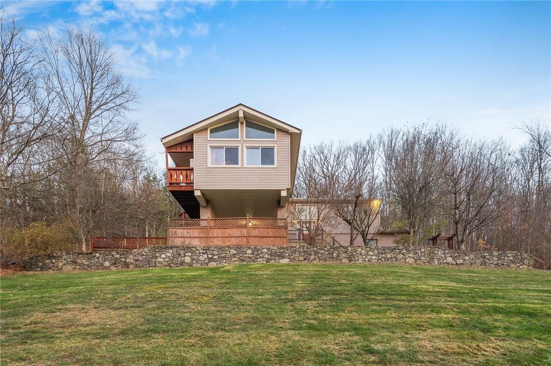 View of property exterior featuring a lawn and a deck