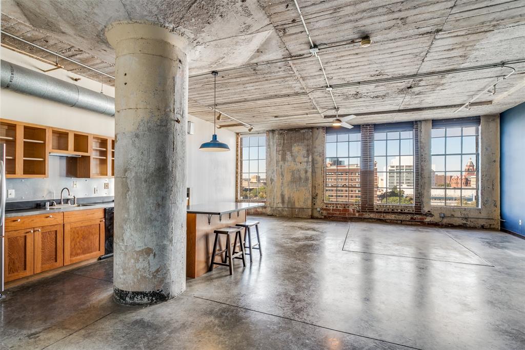 a view of a large room with wooden floor and windows