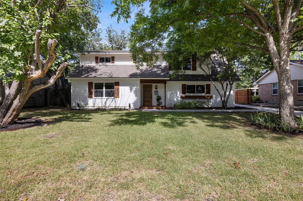 a front view of house with yard and trees