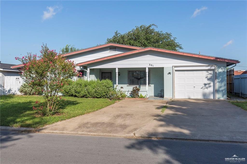 View of front of home with a porch, a garage, and a front lawn