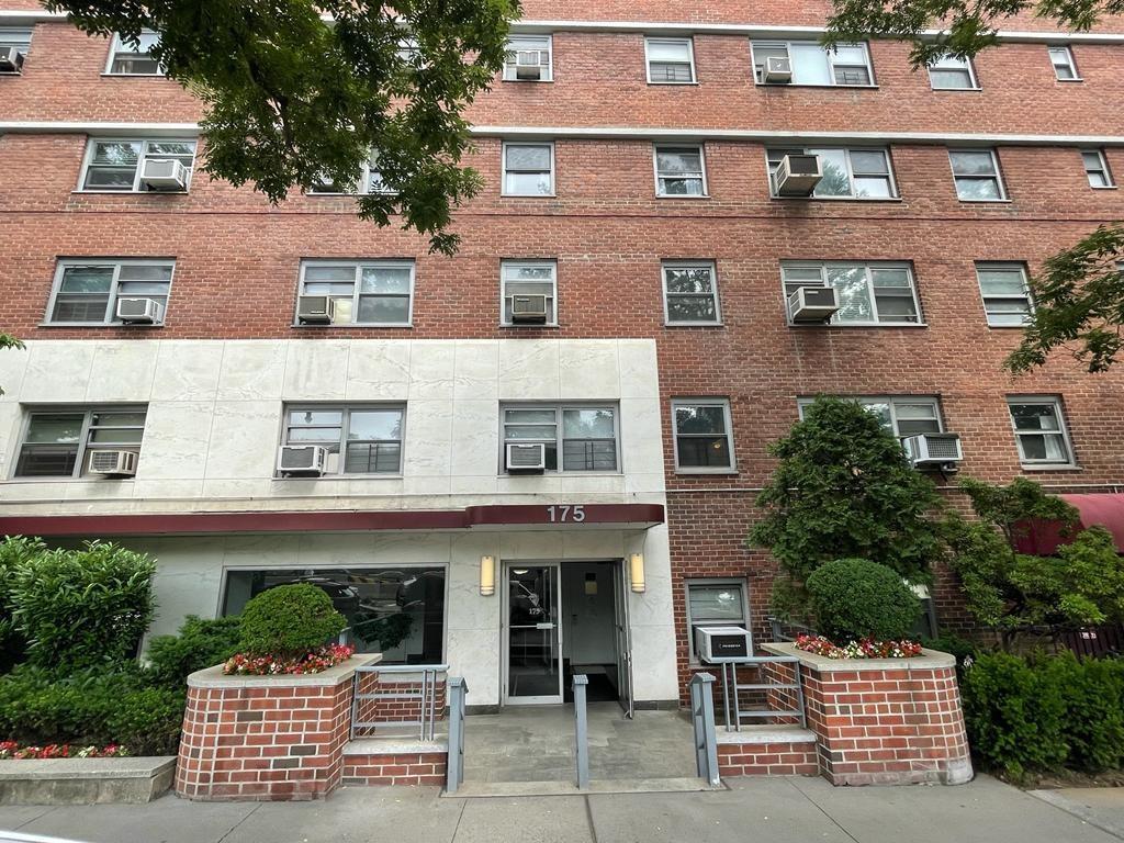 a front view of a multi story building with yard