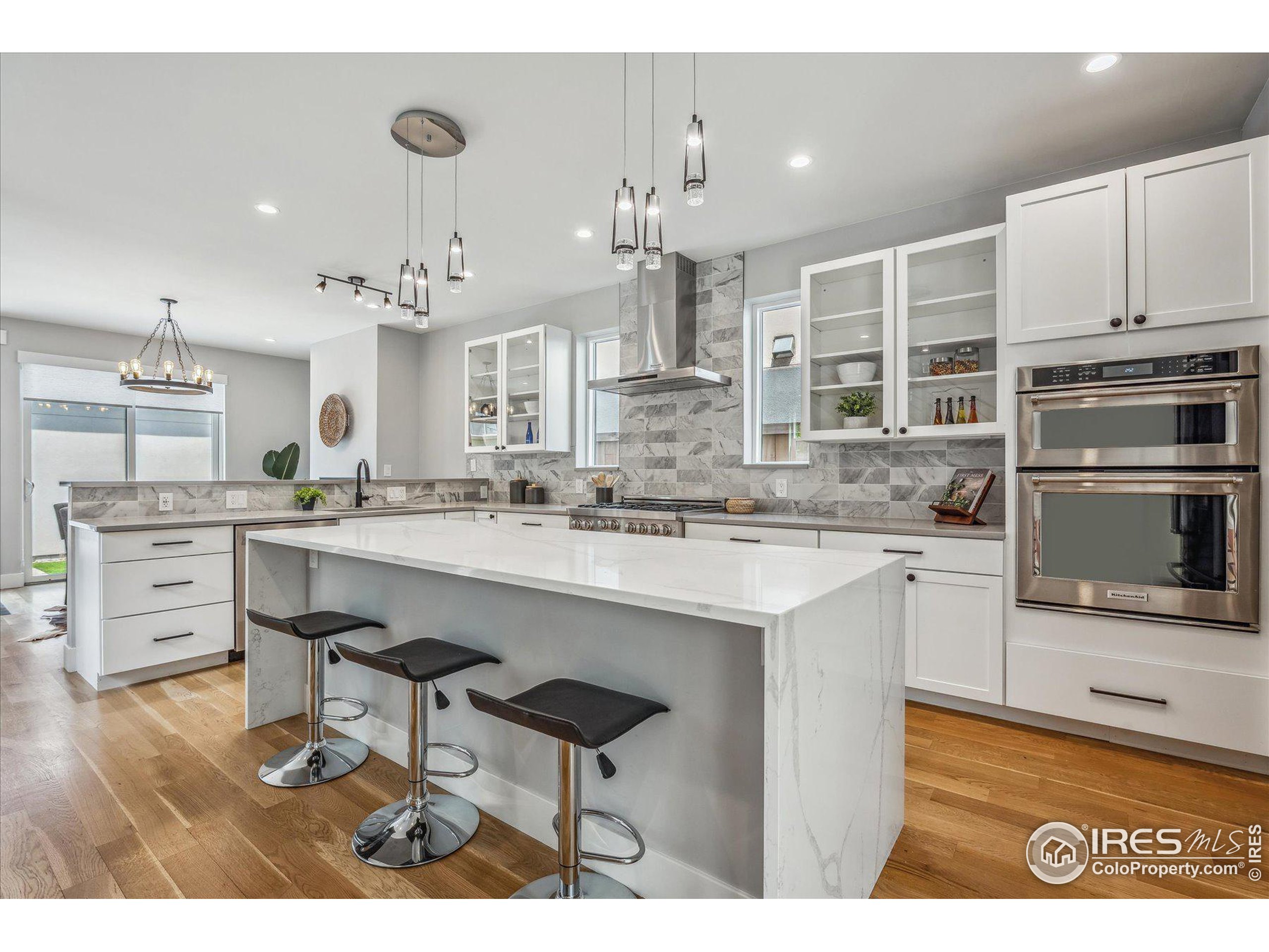 a kitchen with stainless steel appliances kitchen island granite countertop a sink cabinets and wooden floor