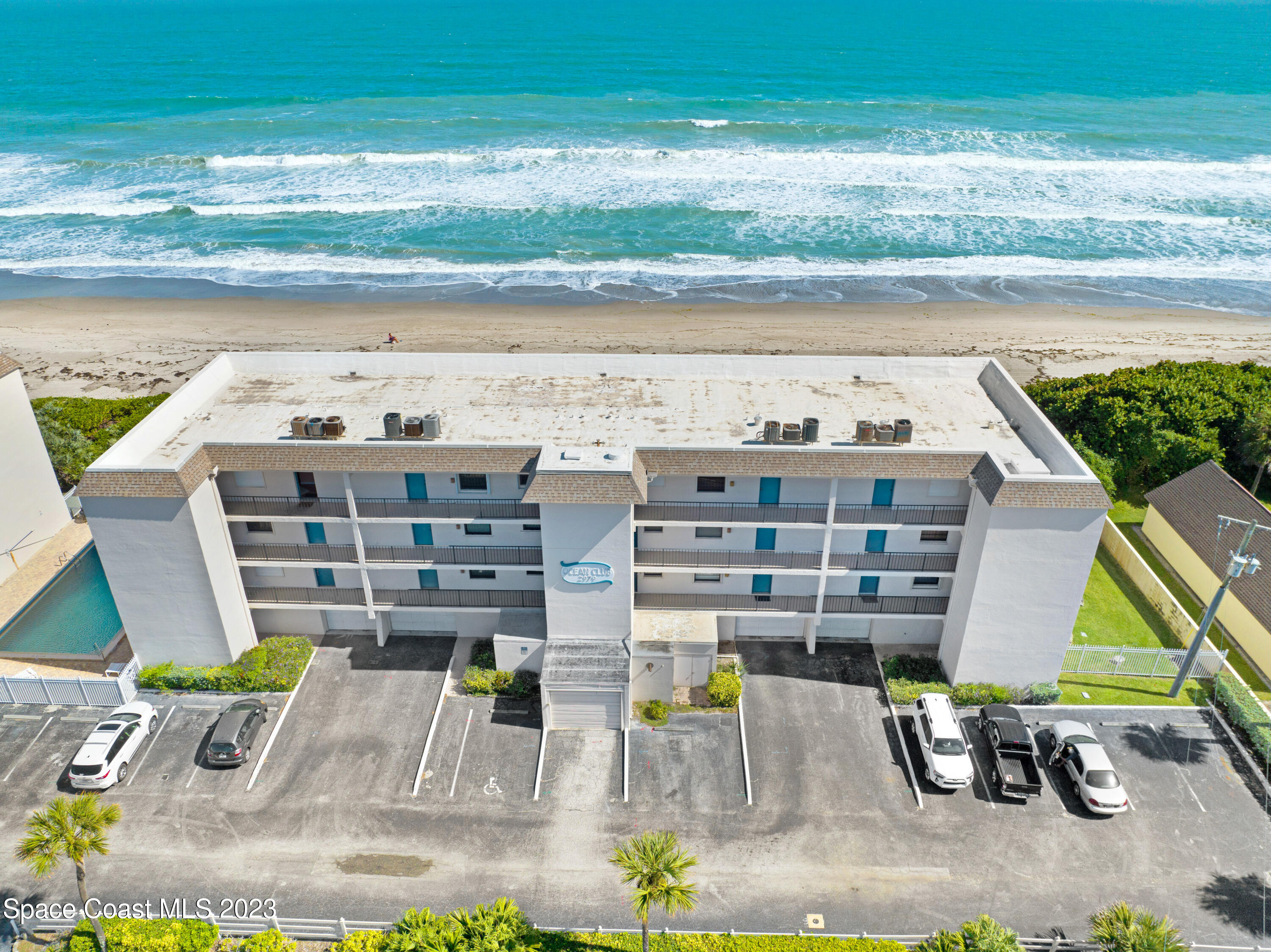 an aerial view of residential houses with outdoor space and ocean view