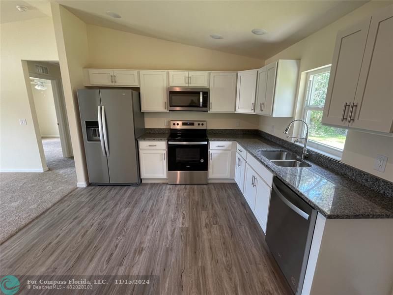 a kitchen with stainless steel appliances a refrigerator microwave and sink