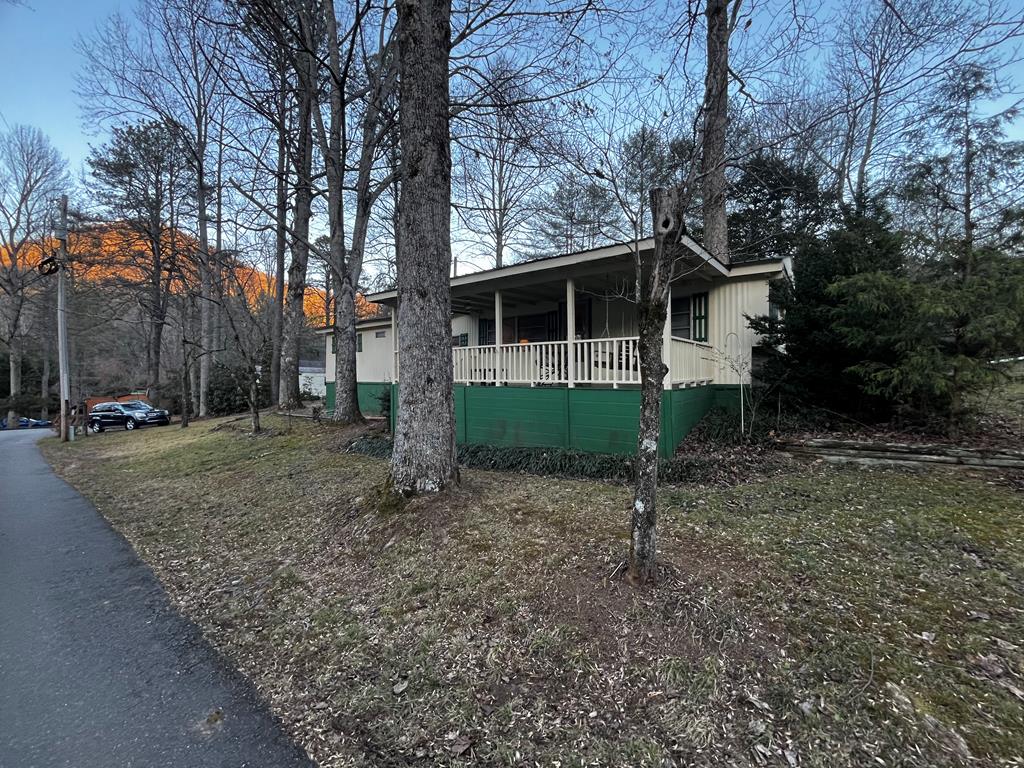 a view of a house with a backyard and trees