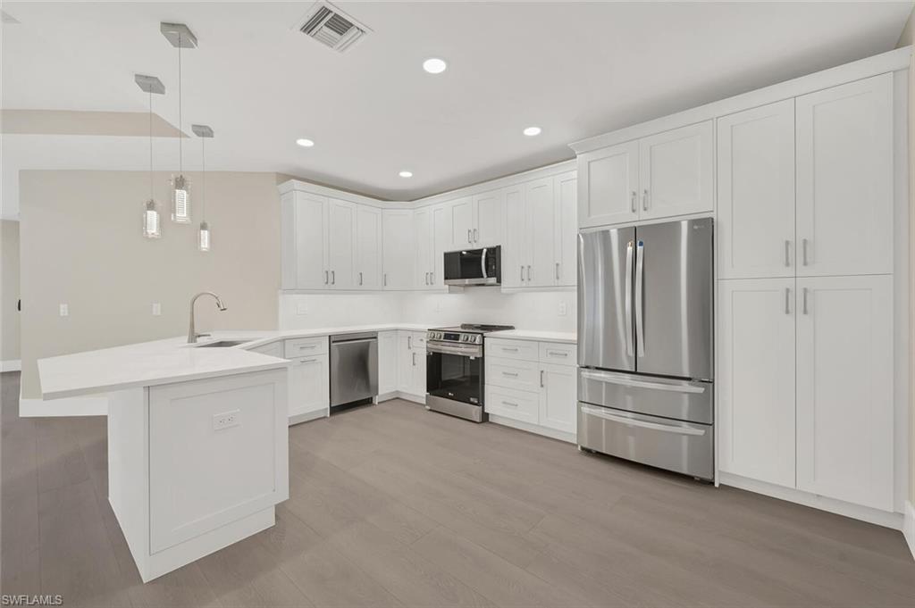 a kitchen with white cabinets and white appliances