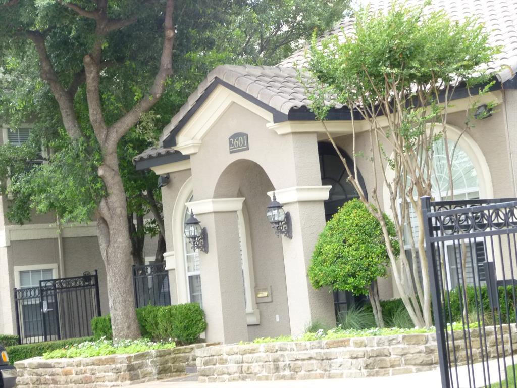 a view of a white house with large windows and a small yard