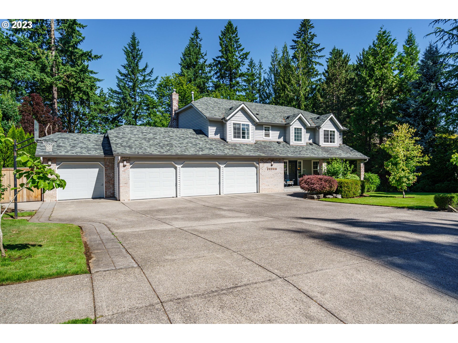 a front view of a house with a yard and trees