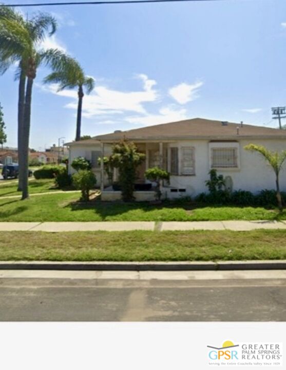 a front view of a house with a garden and yard