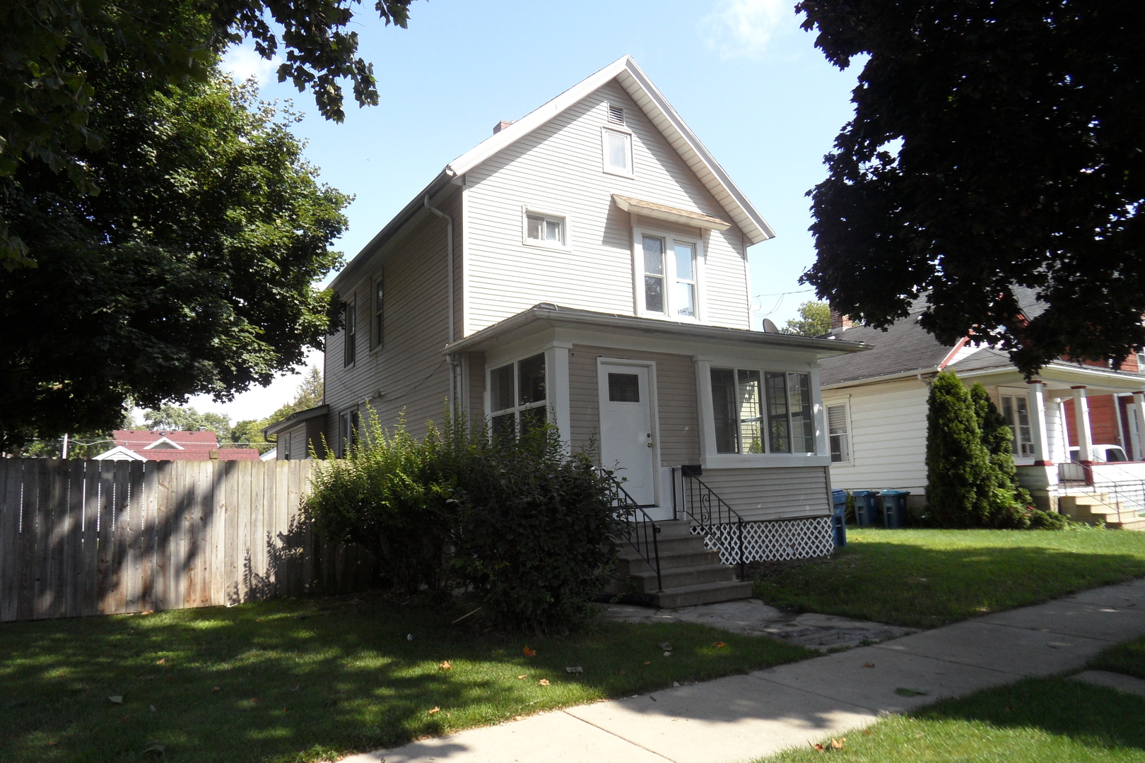 a front view of a house with a garden and trees