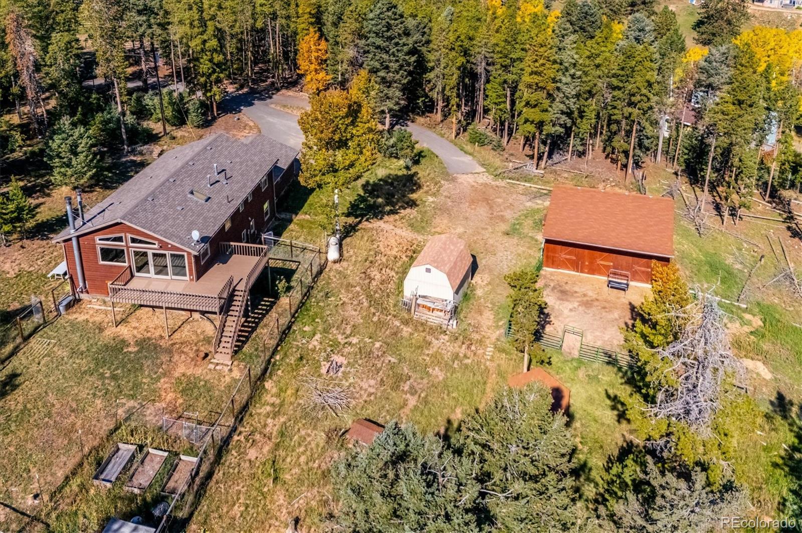 an aerial view of residential house with outdoor space and trees all around