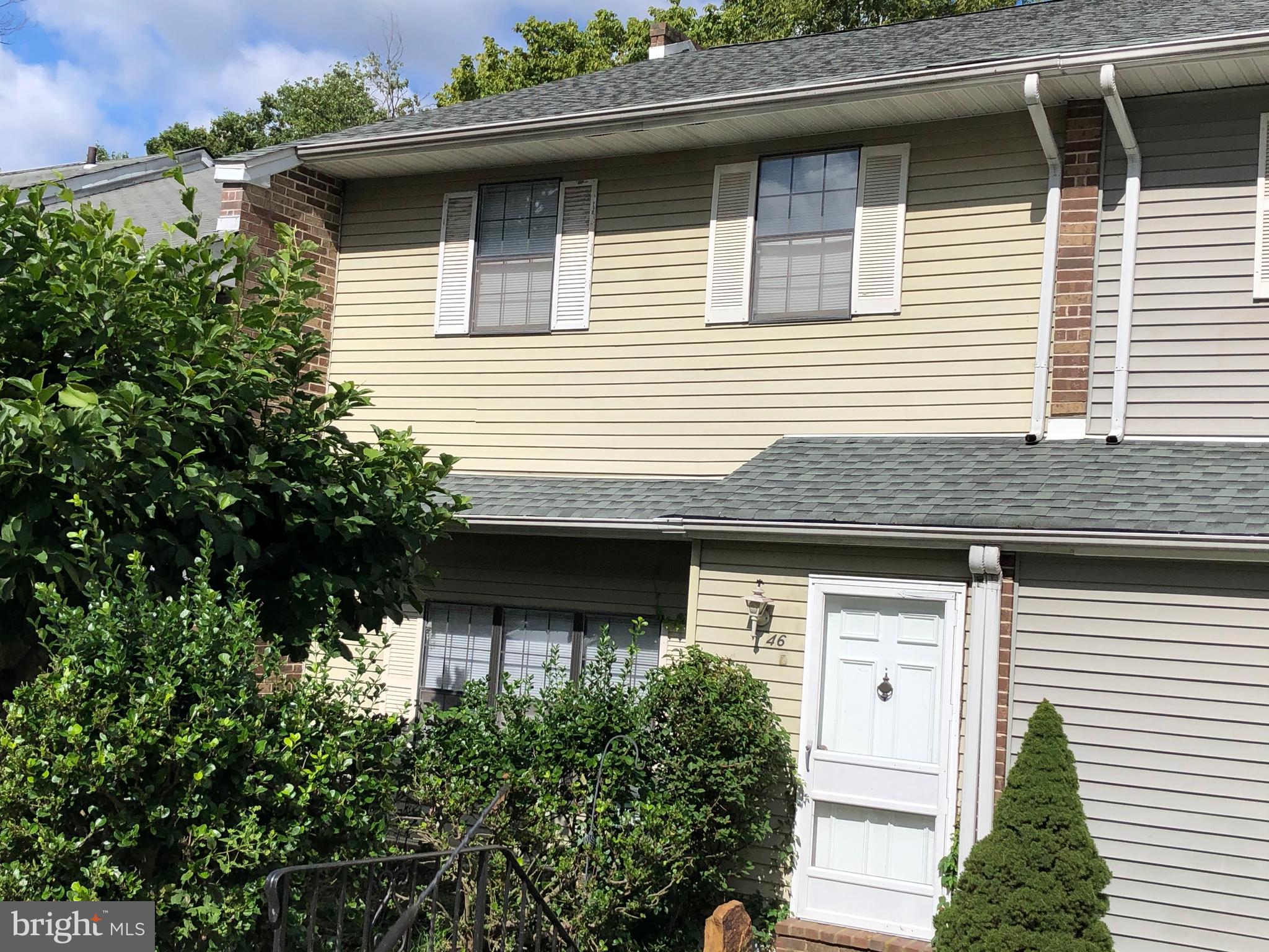 a front view of a house with plants