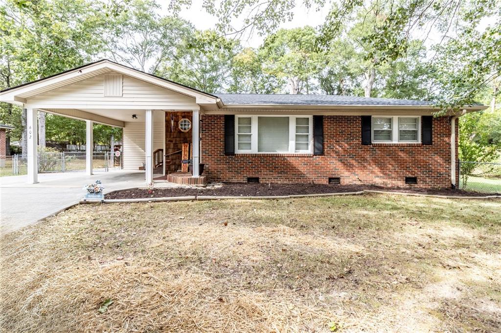 a front view of house with yard outdoor seating and barbeque oven