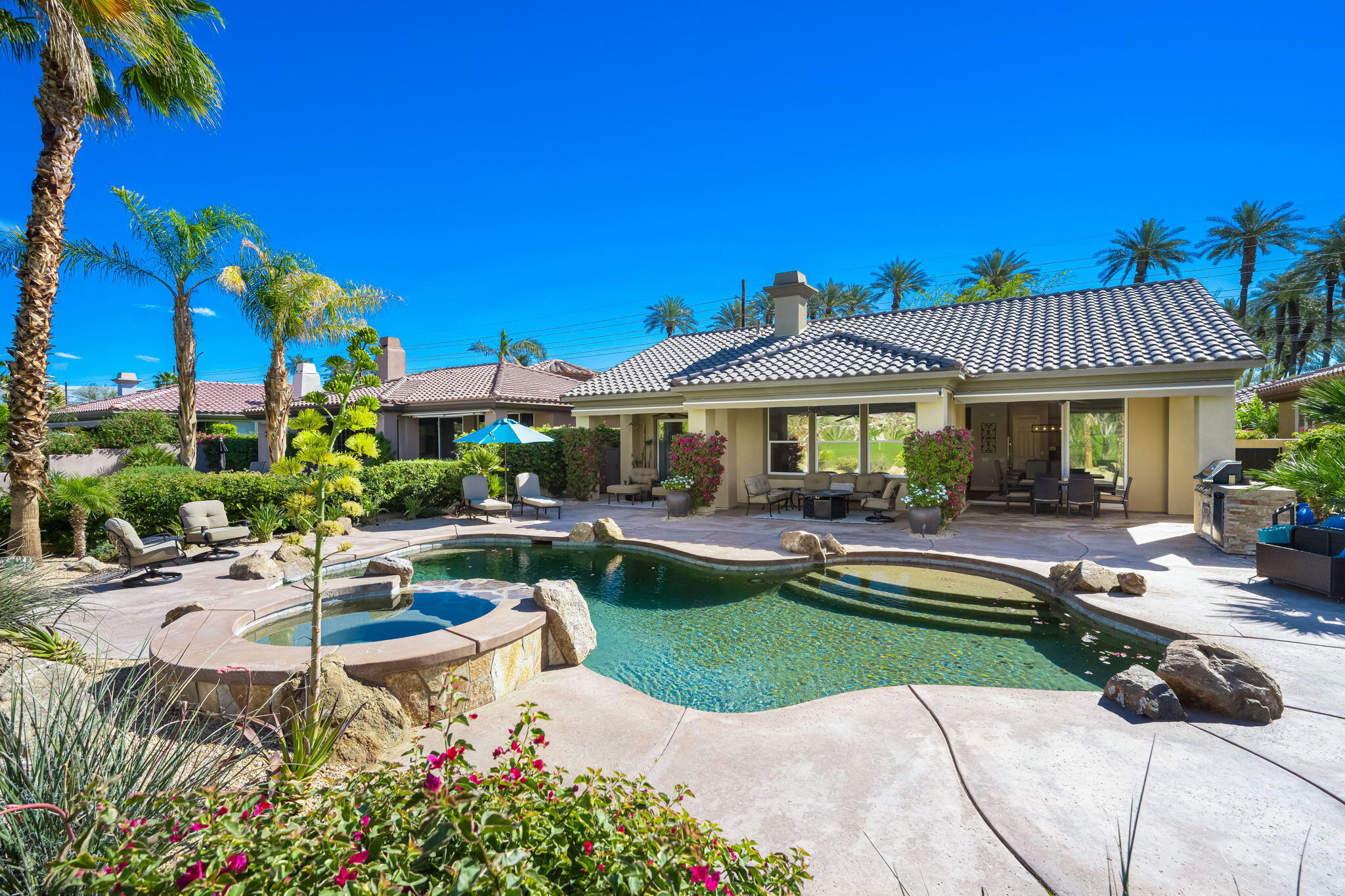 a front view of a house with swimming pool having outdoor seating