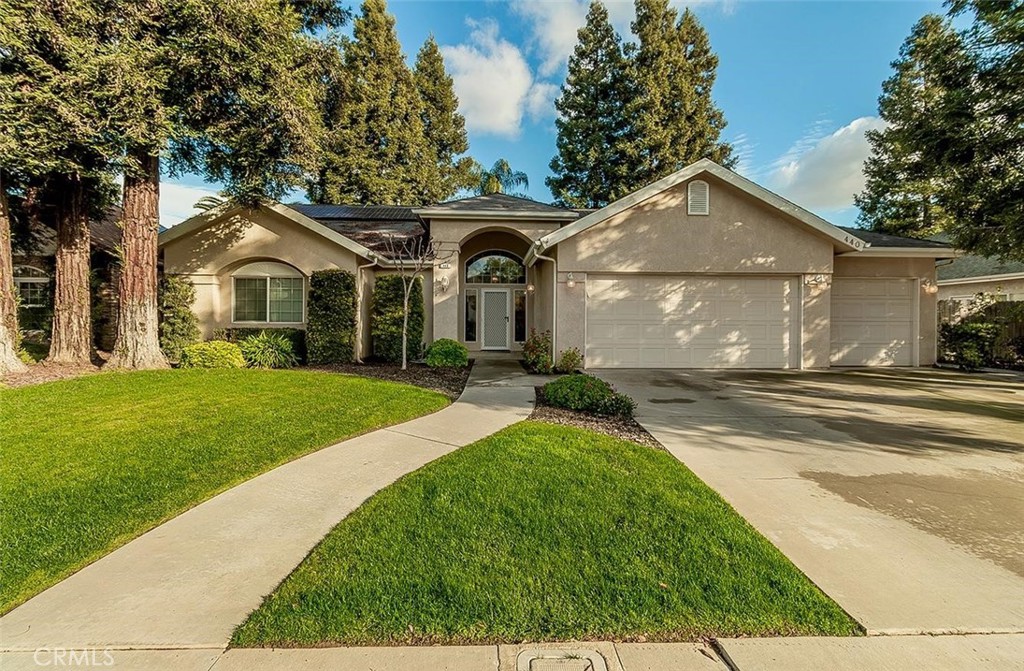 a front view of a house with a yard and trees