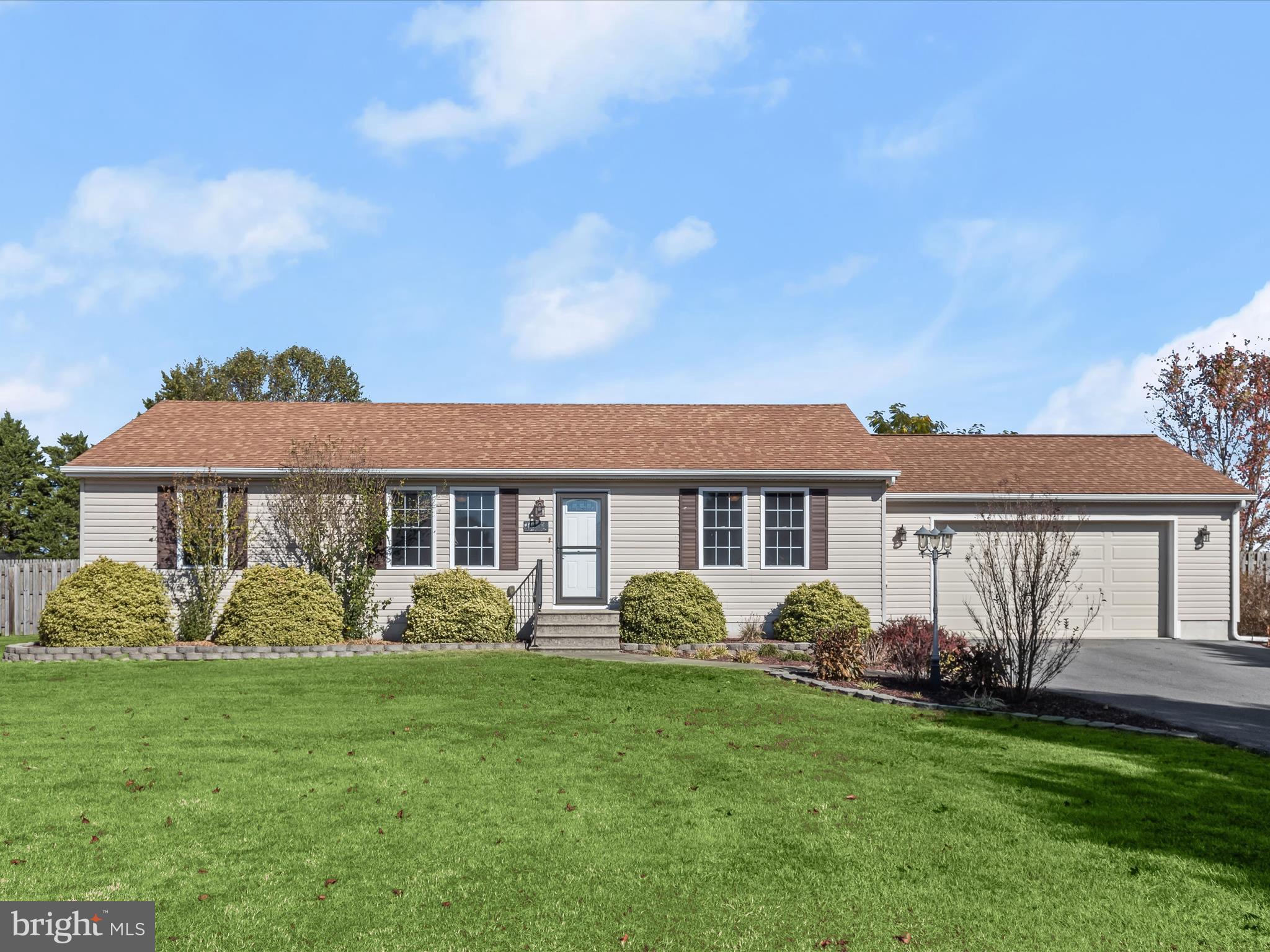 a front view of a house with a yard and trees