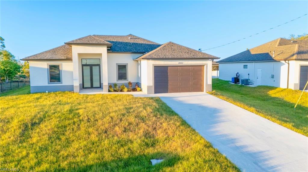 View of front of property featuring a front yard and a garage