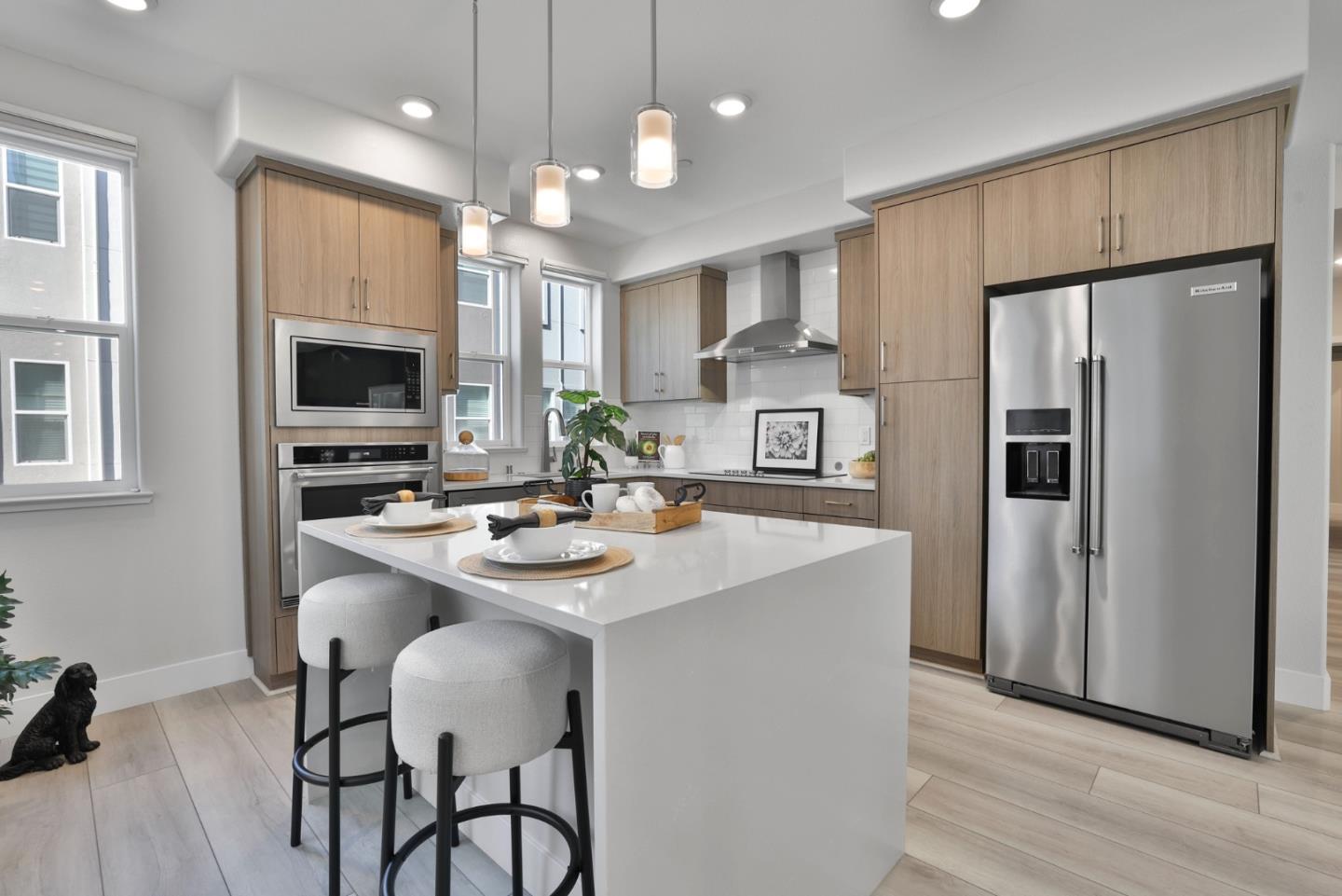 a kitchen with refrigerator a sink and chairs