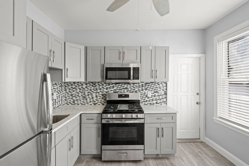 a kitchen with white cabinets and stainless steel appliances