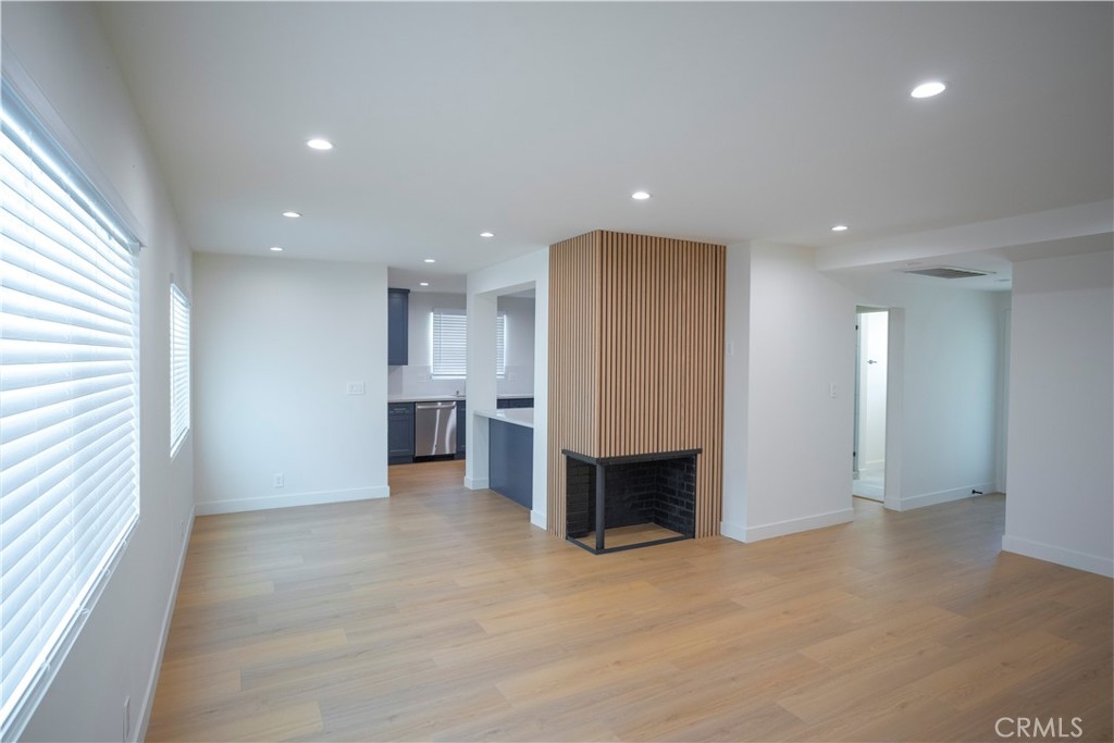 an empty room with kitchen view and a window