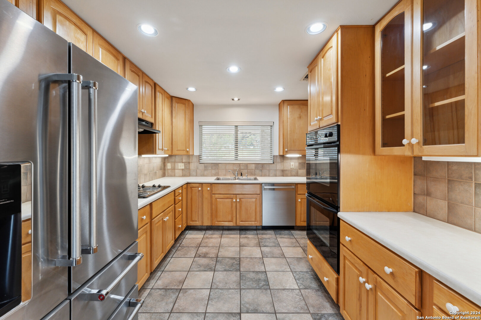 a kitchen with a sink refrigerator and cabinets