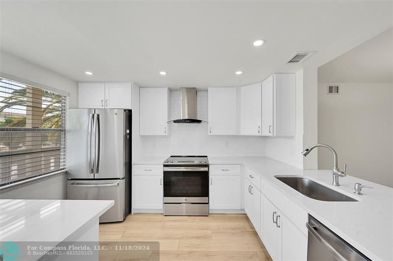 a kitchen with a sink stainless steel appliances and cabinets