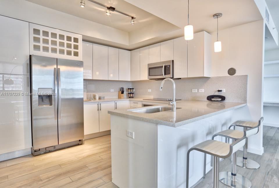 a kitchen with kitchen island a sink appliances and cabinets