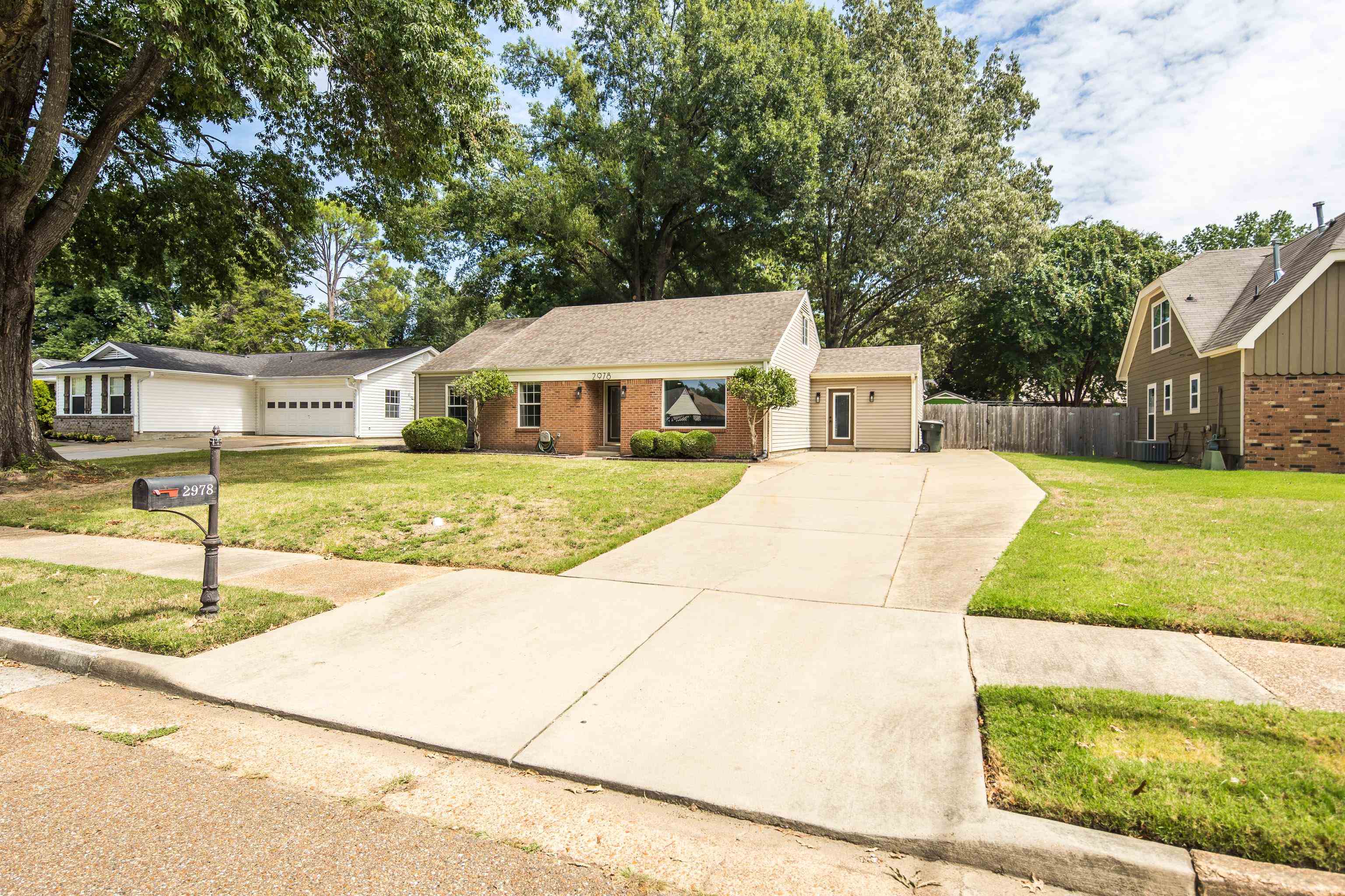 Ranch-style home featuring a garage, a front yard, and cooling unit