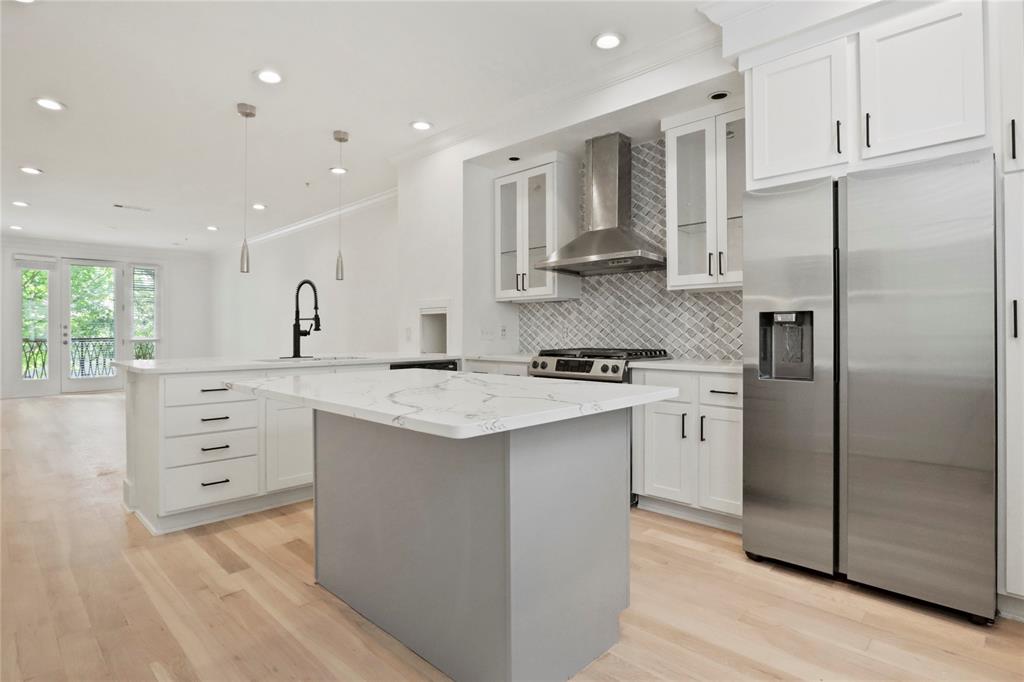 a kitchen with stainless steel appliances kitchen island granite countertop a refrigerator and a stove top oven