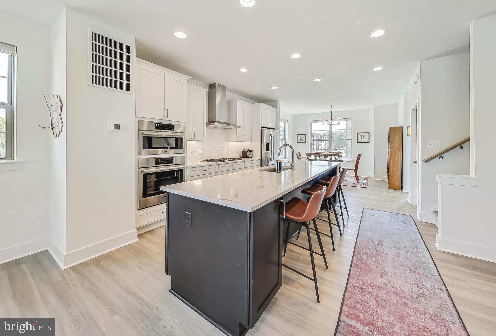 a kitchen with stainless steel appliances kitchen island granite countertop a refrigerator and a sink