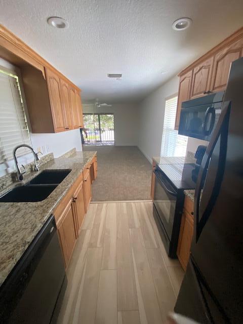 a kitchen with granite countertop a sink stove and cabinets