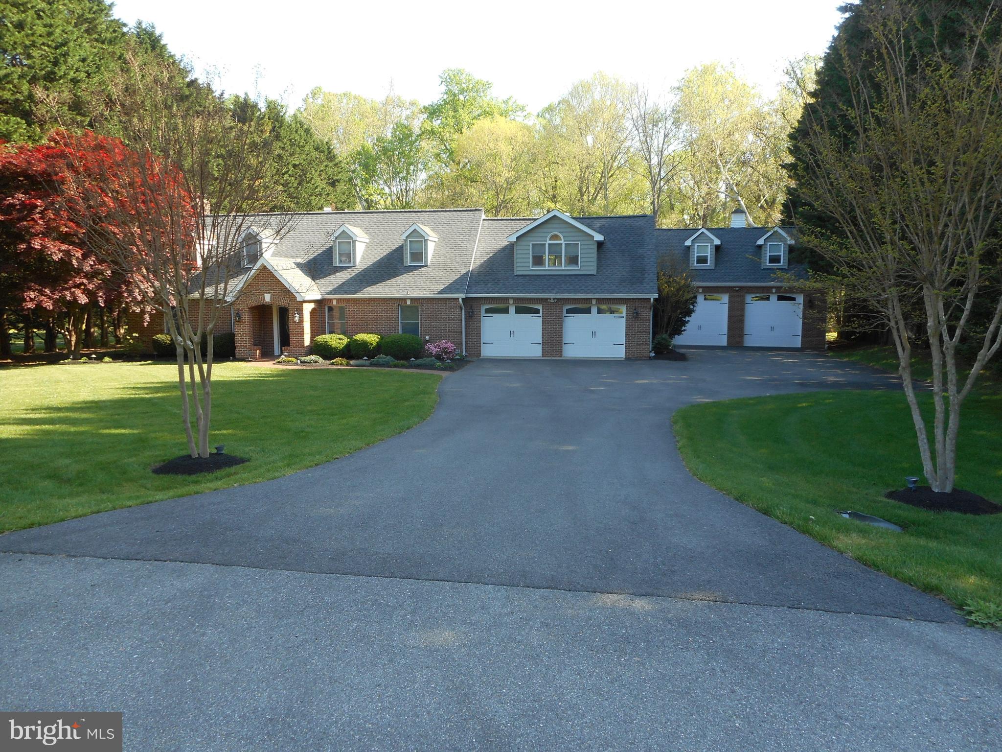 a view of a big house with a big yard and large trees