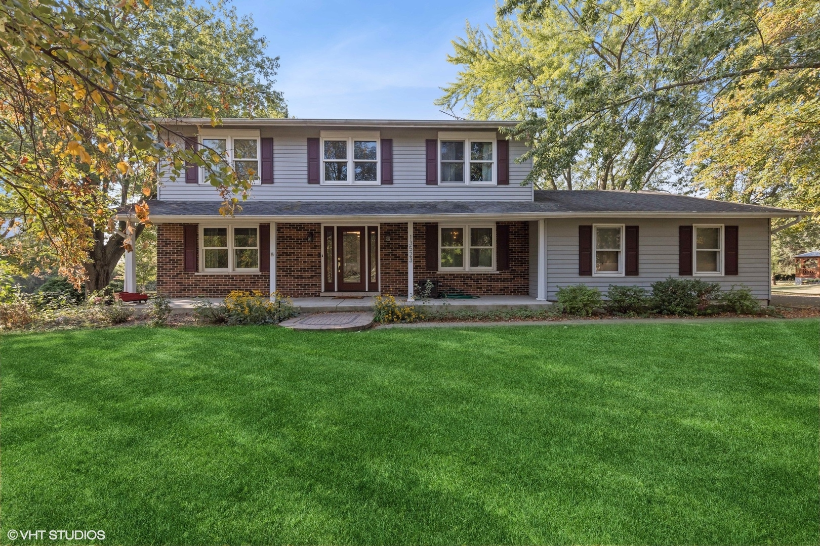 a front view of a house with a yard and trees