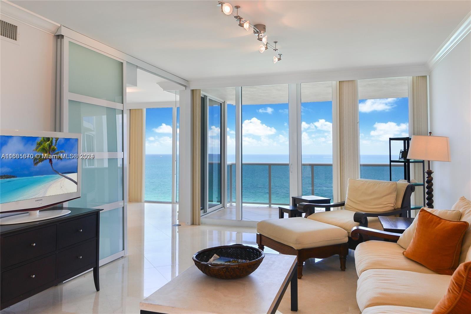 a living room with furniture and a floor to ceiling window