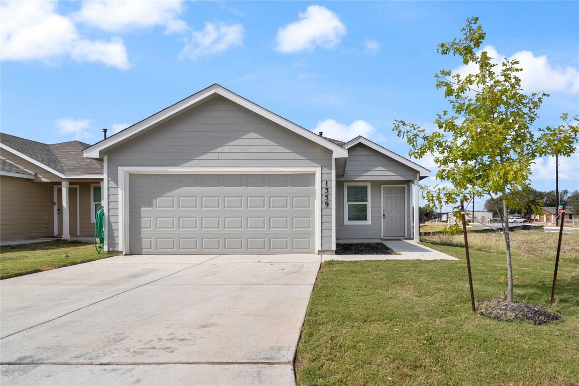 a view of a house with a yard and garage