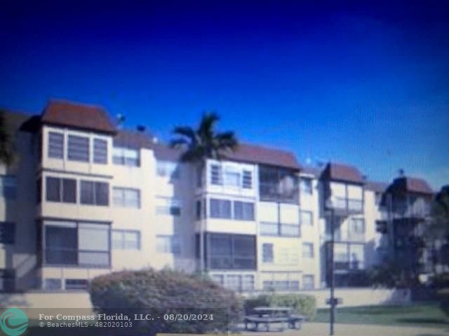 a front view of a residential apartment building with a yard